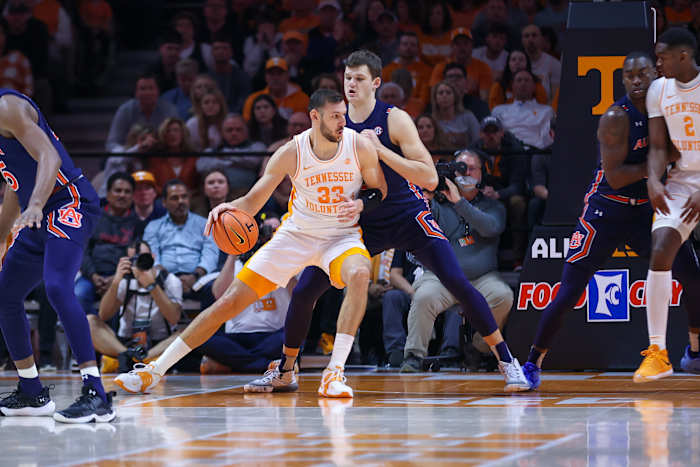 Feb 26, 2022; Knoxville, Tennessee, USA; Tennessee Volunteers forward Uros Plavsic (33) moves the ball against Auburn Tigers forward Walker Kessler (13) during the first half at Thompson-Boling Arena. Mandatory Credit: Randy Sartin-USA TODAY Sports